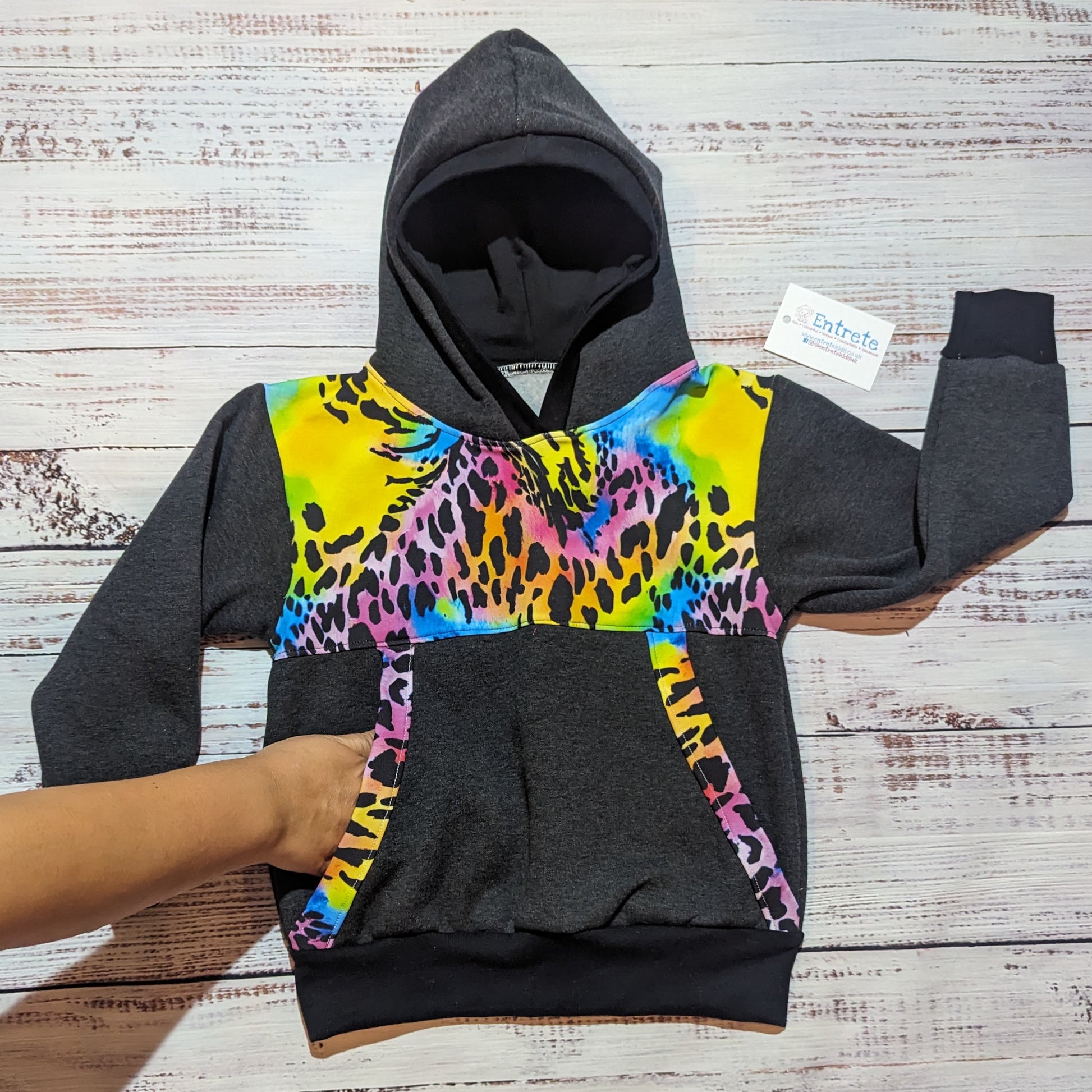 The vivid neon animal print Mama and mini hoodie set. Handmade using neon animal print and charcoal cotton French Terry's and cotton ribbing. Demonstrating the front pocket.