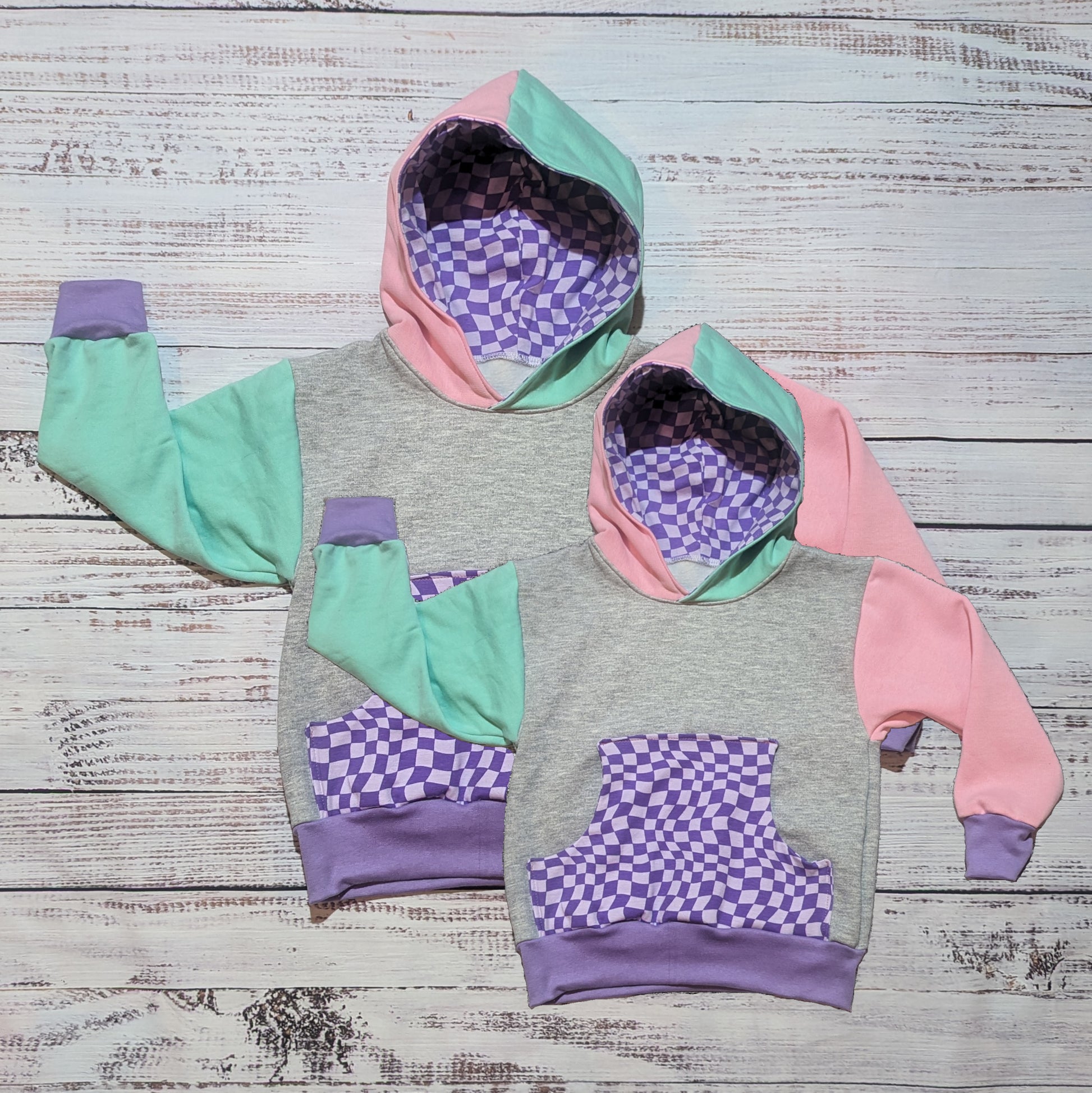 Mama and mini matching hoodie set. Handmade in purple trippy checked cotton jersey, pink, mint and grey cotton French terry and purple cotton ribbing. A fun mix of patterns and colours that you can rock together.