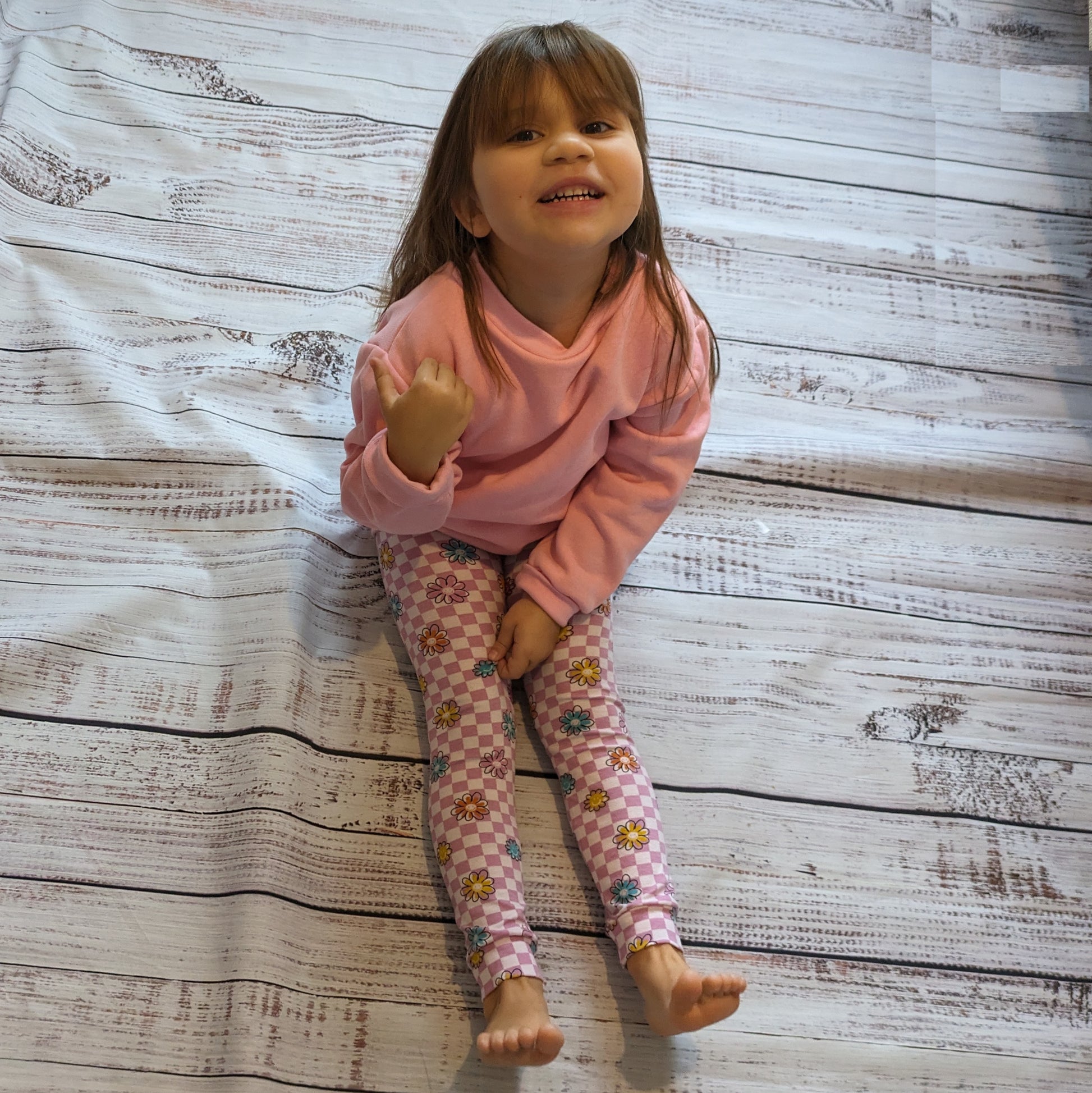 Sophie in her pink checked happy flowers leggings, with a pink checked happy flowers heart sweatshirt.