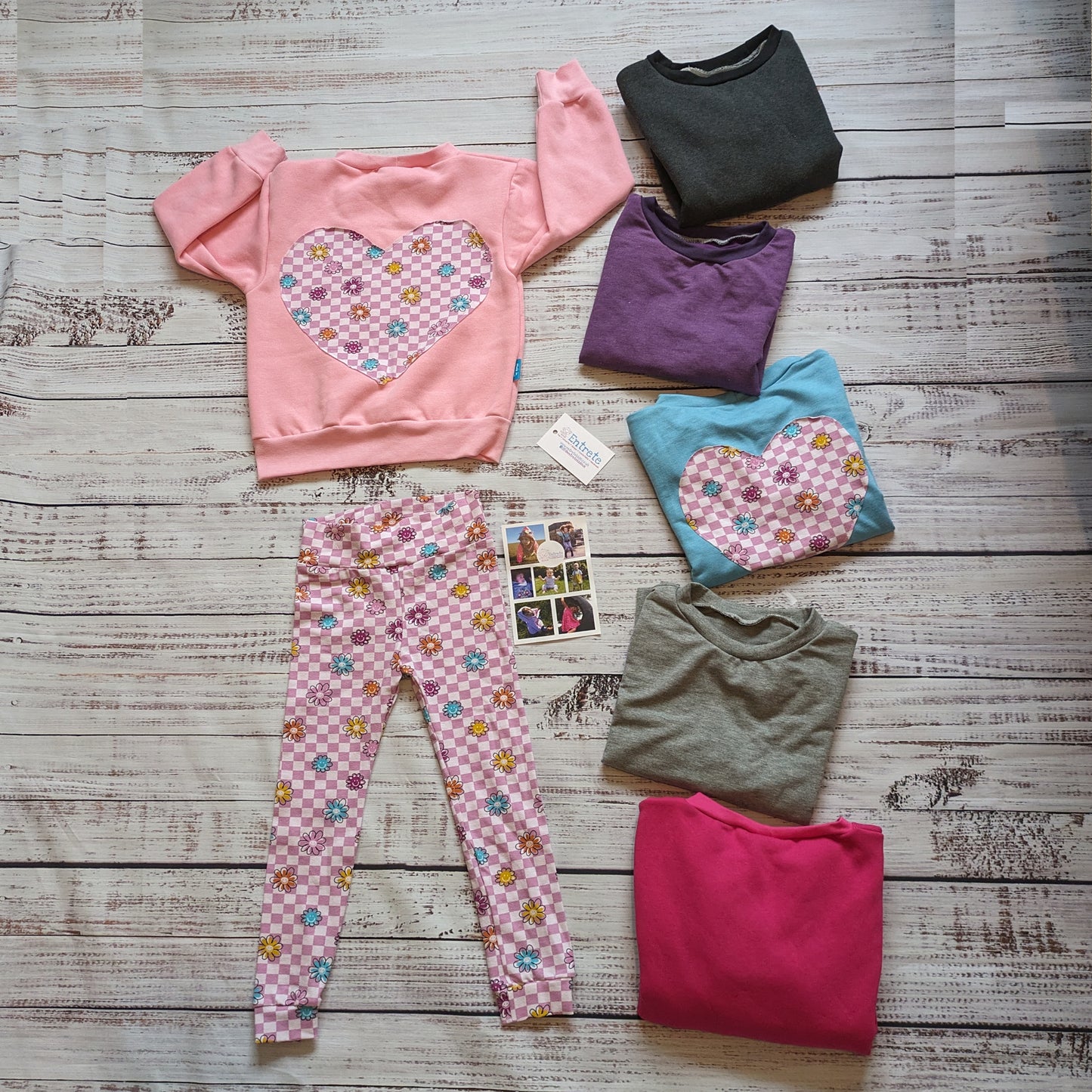 Soft and stretchy kids leggings handmade using pink checked happy flowers cotton jersey. With smiling flowers on a pink checked background. Shown with our range of pink checked happy flowers heart sweatshirts.