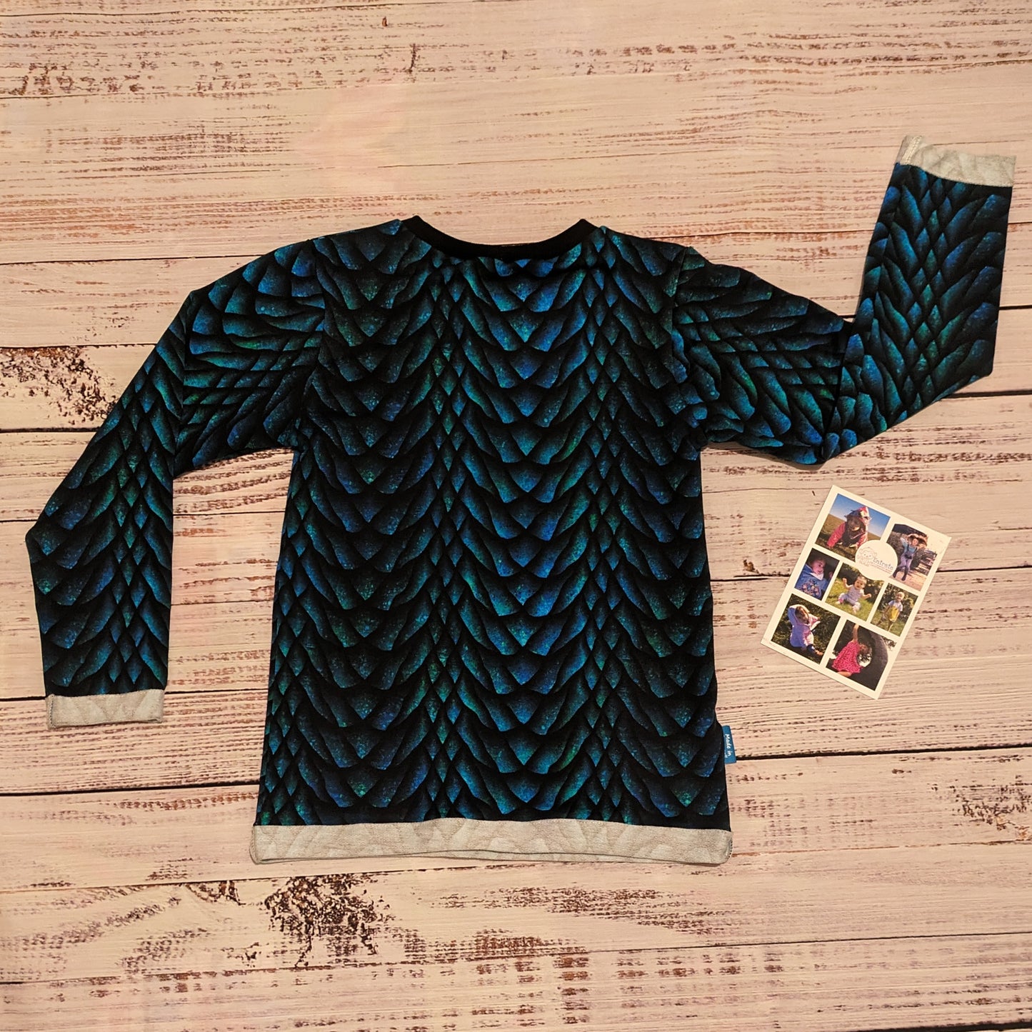 The gorgeous glimmering dragon scales T-shirt. Handmade using dragon scales cotton French terry and black cotton ribbing. Showing the long sleeve version from the back. 