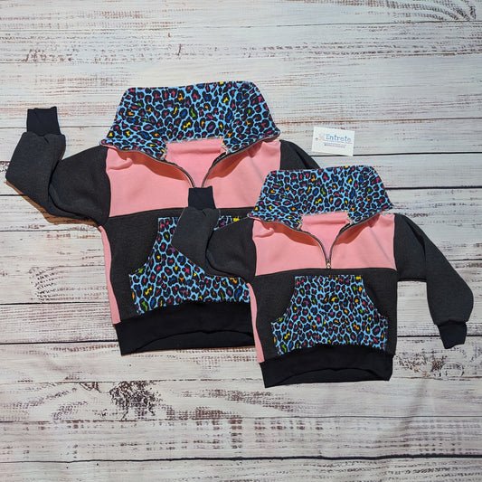 Matching Mama and mini neon leopard print, pink and charcoal sweatshirts. With a zipped collar, that can be open to reveal the colourful animal print or closed for warmth.