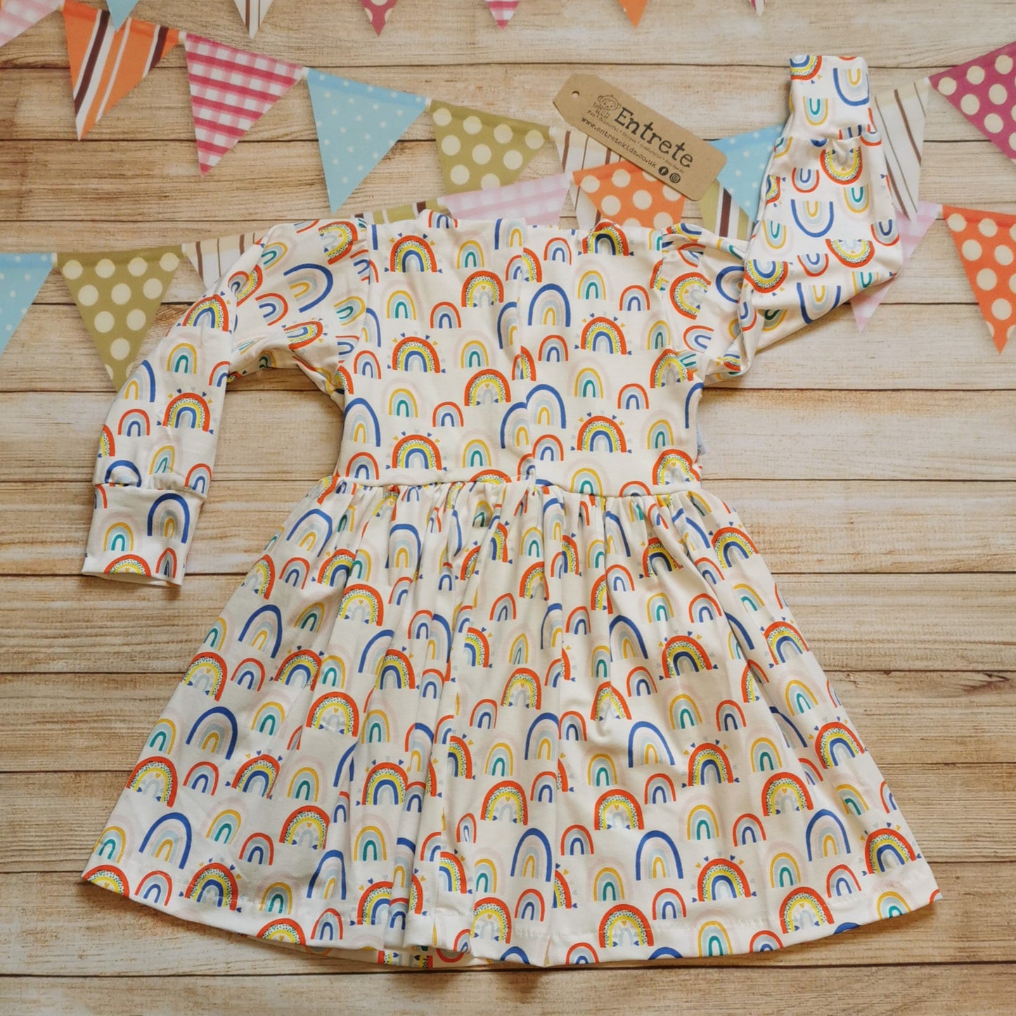 Rear of Girls & toddlers back popper dress, handmade using the fun white colourful rainbows and hearts cotton jersey.