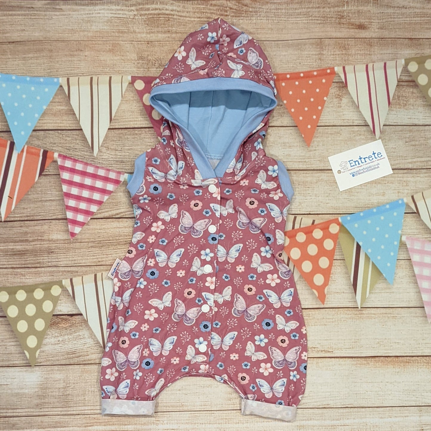 Pretty pink butterflies hooded bummie romper. Handmade using organic pink butterflies cotton jersey, sky blue cotton jersey and sky blue cotton ribbing.