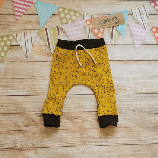 Front view of the warm, soft and comfy ochre dots harem joggers. Handmade from ochre dots cotton french terry and chocolate cotton ribbing.