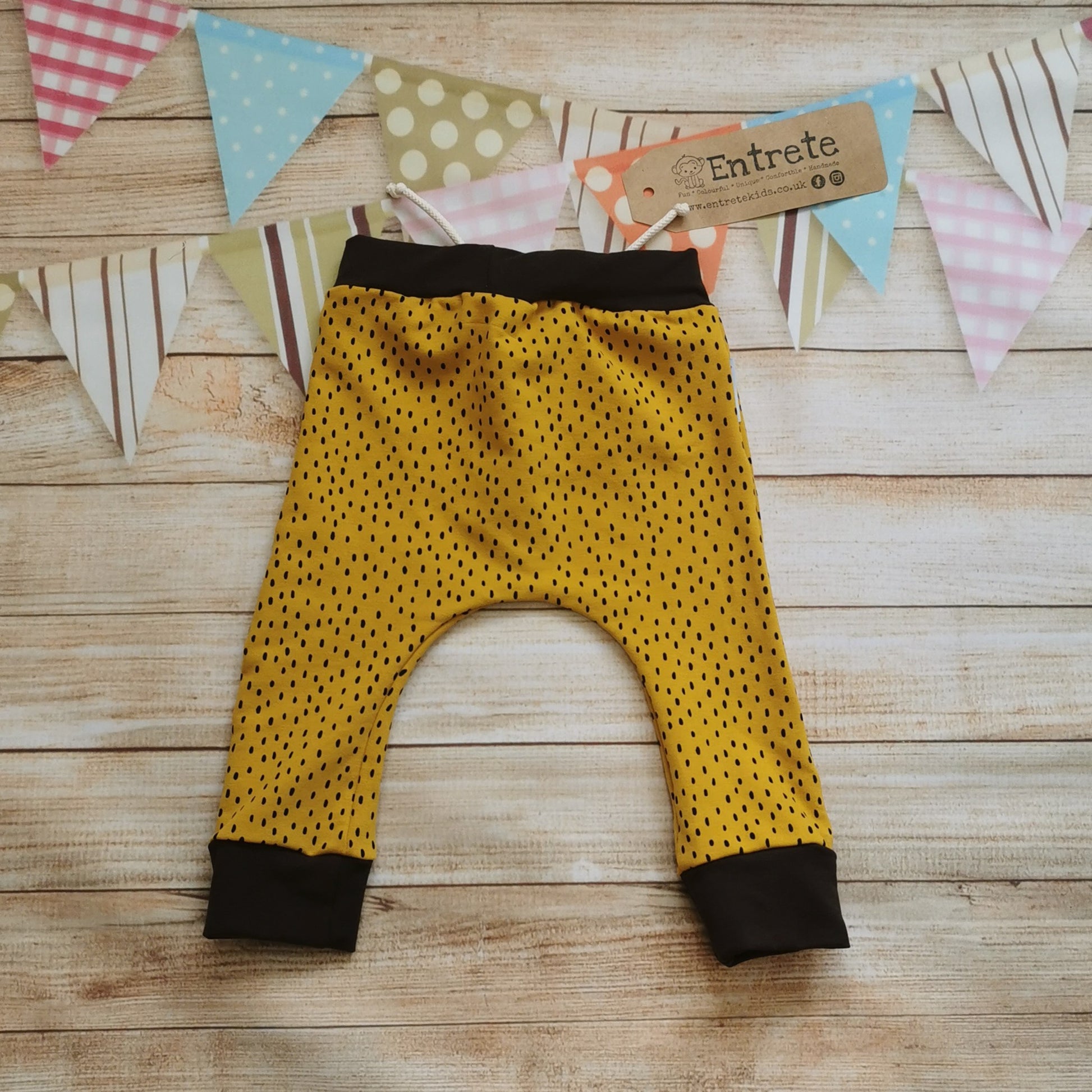 Rear view of the warm, soft and comfy ochre dots harem joggers. Handmade from ochre dots cotton french terry and chocolate cotton ribbing.