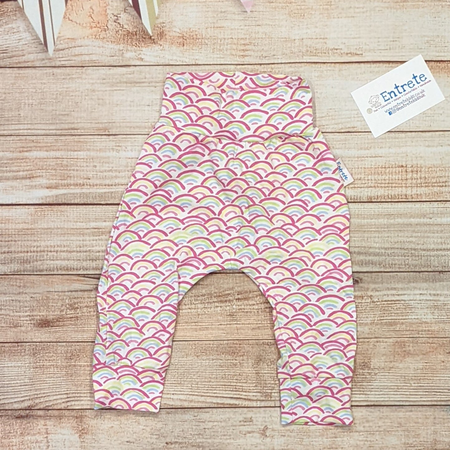 The adorable mini rainbows harem pants with a soft non elasticated waist, perfect for younger children. Handmade using mini rainbows on white cotton jersey. Shown from the rear.