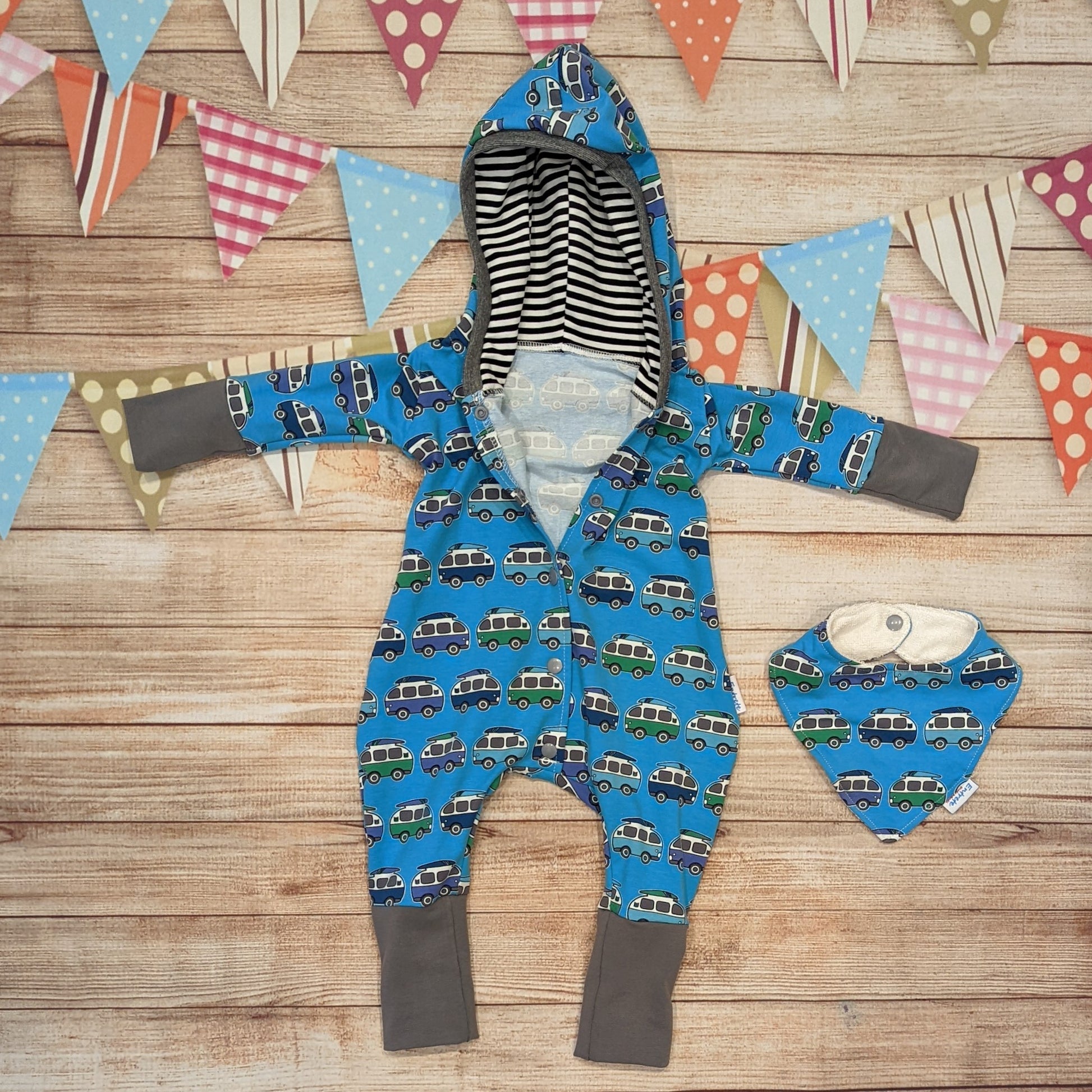 Kids hooded long sleeve romper, handmade using blue surf campervan cotton jersey, contrasting grey cotton jersey cuffs, grey ribbing around the hood and striped hood lining. Shown with poppers open. and a matching bamboo bib.