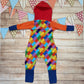 The unique, colourful building blocks hooded romper. Handmade using colourful building blocks, royal blue, red, yellow and orange cotton jersey's with green cotton ribbing. Shown from the rear.