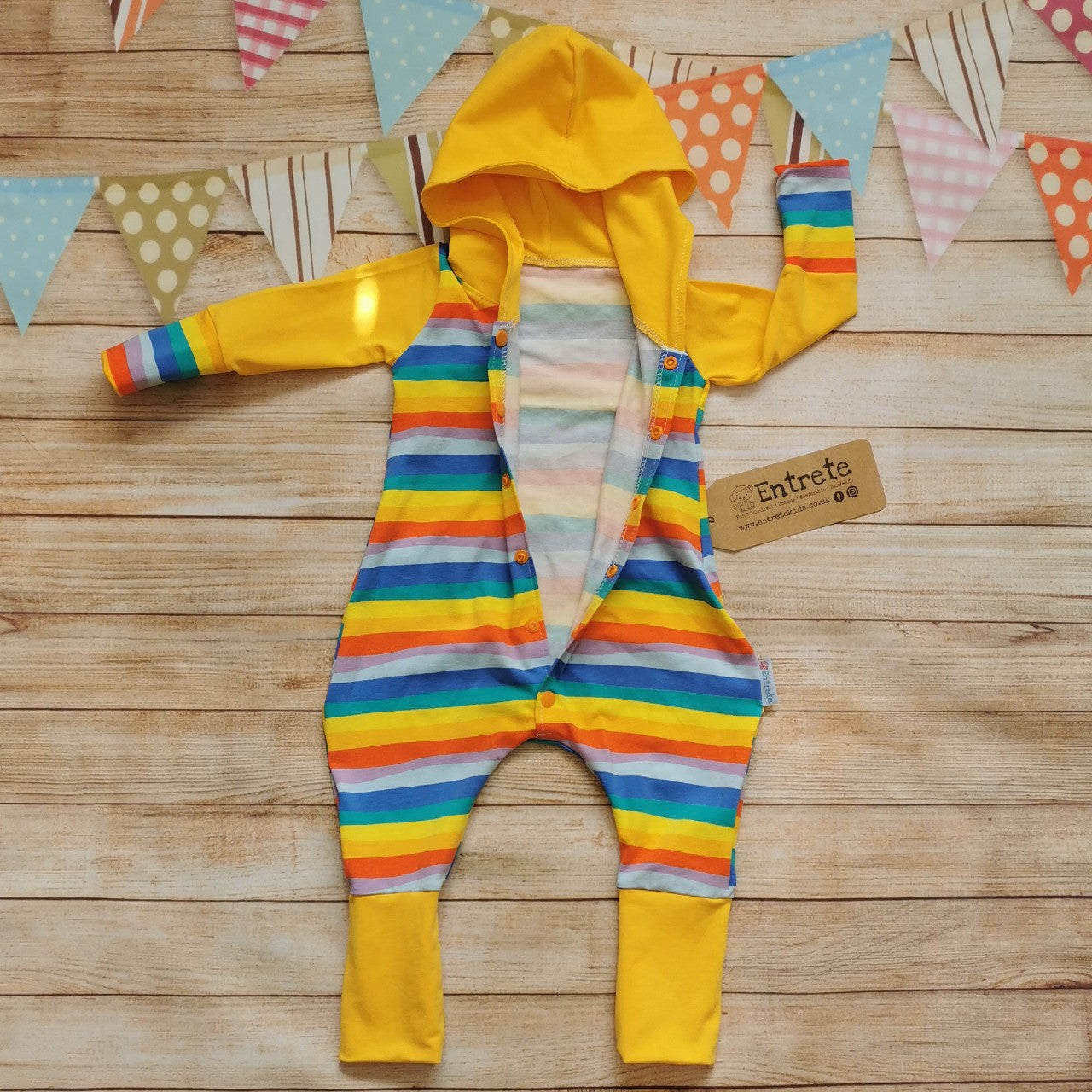 Unisex kids hooded popper romper, handmade with red rainbow striped cotton jersey body and cuffs, organic yellow cotton jersey hood, arms and lower legs. Shown with poppers open, for easy entry.