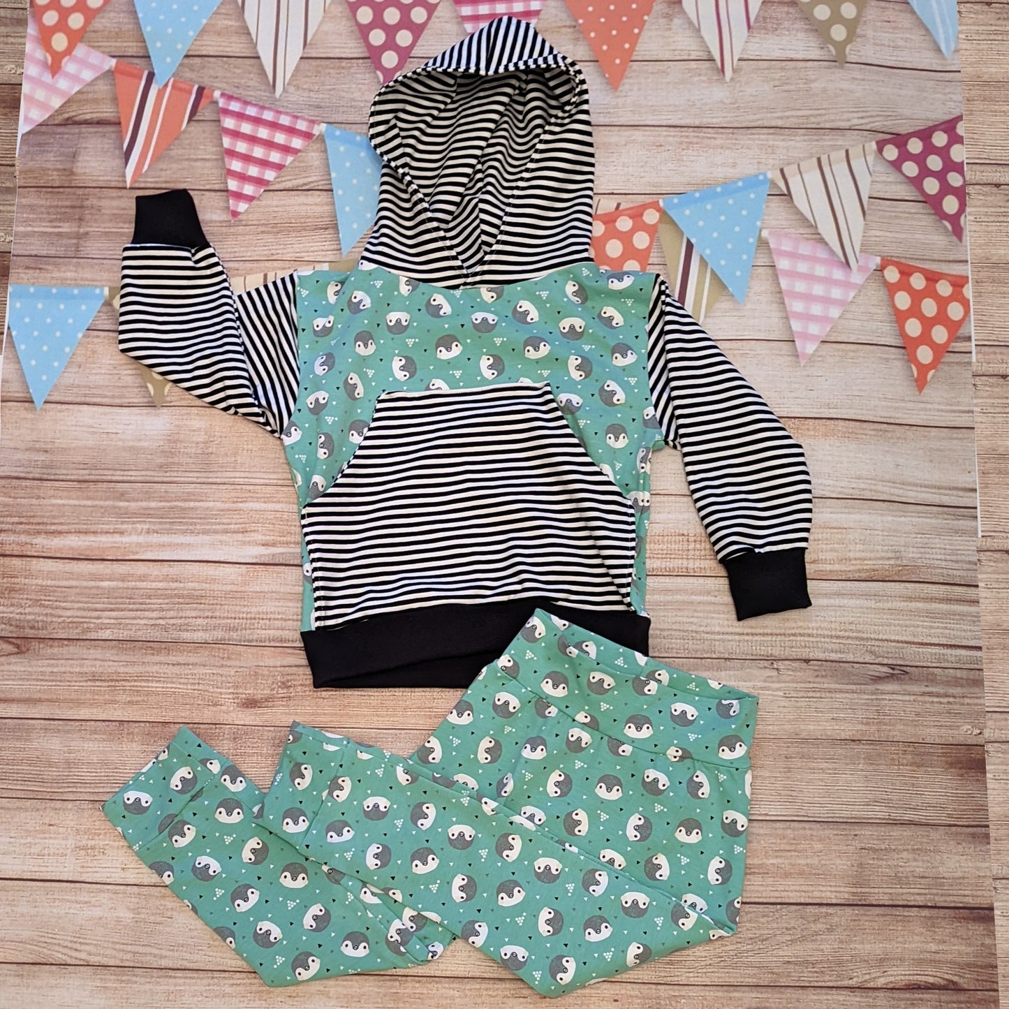 The adorable organic mint penguins harem joggers shown as an outfit with a matching hoodie.