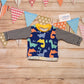 Colourful and fun blue dinosaurs long sleeved T-Shirt. Handmade using blue dinosaurs and monochrome striped cotton jersey's with yellow cotton ribbing.