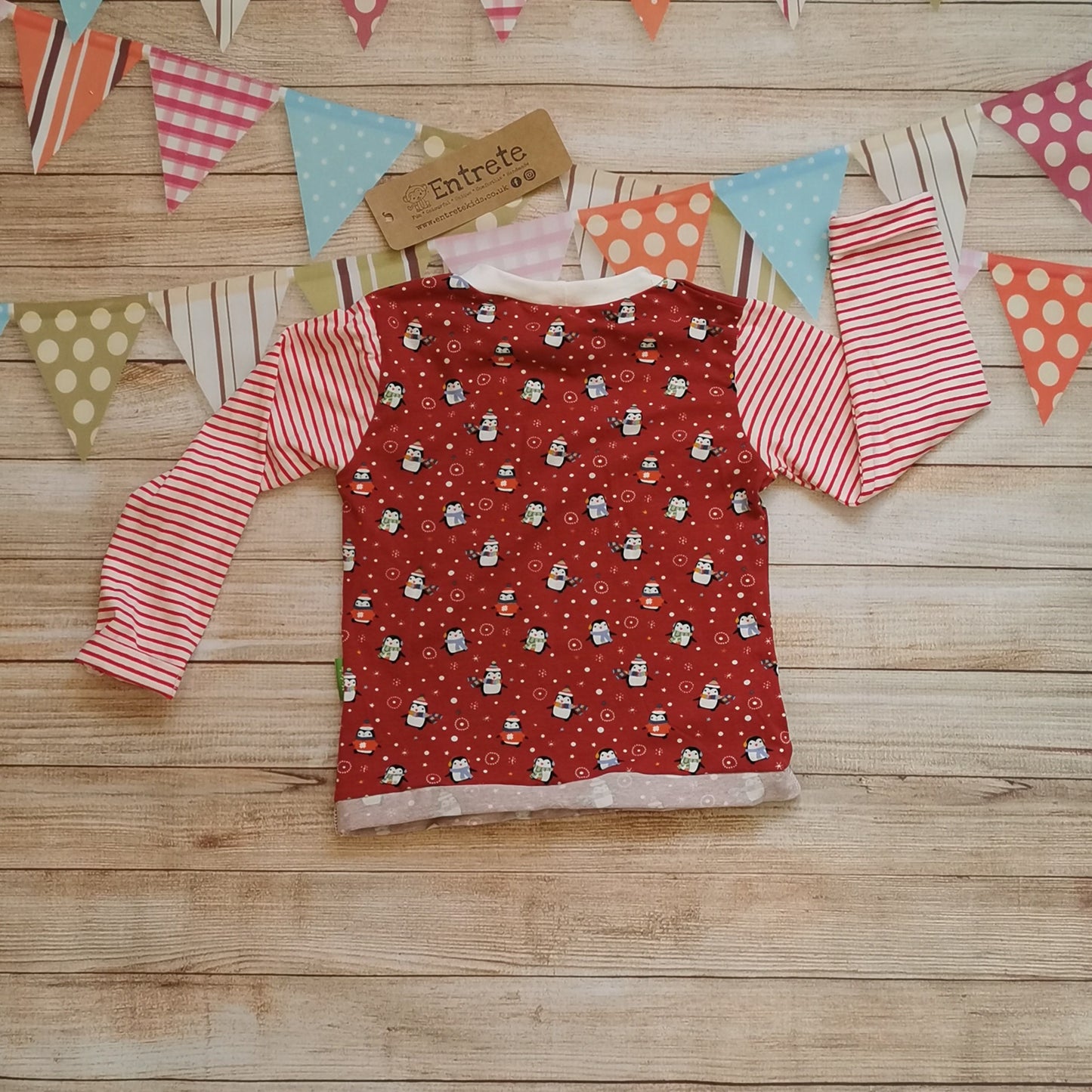 Rear view of long sleeve T-shirt handmade using fun and festive red penguins cotton jersey, red striped cotton jersey and white cotton ribbing. A great Christmas look.