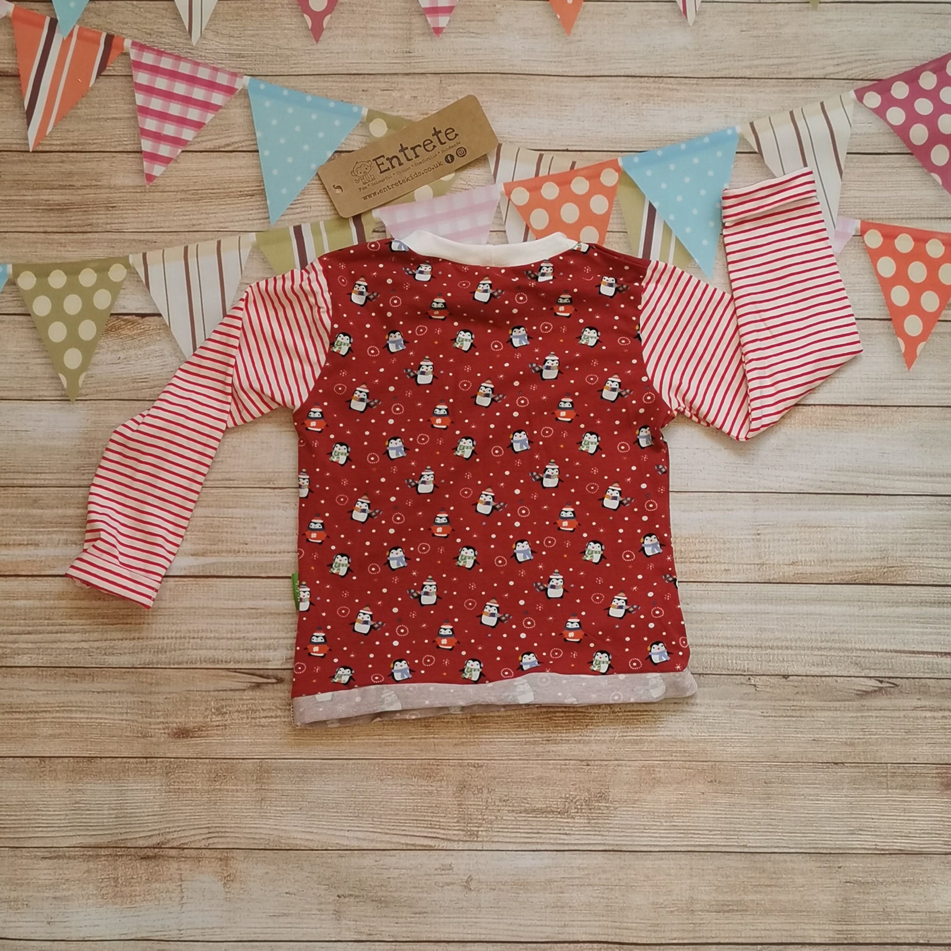 Rear view of long sleeve T-shirt handmade using fun and festive red penguins cotton jersey, red striped cotton jersey and white cotton ribbing. A great Christmas look.