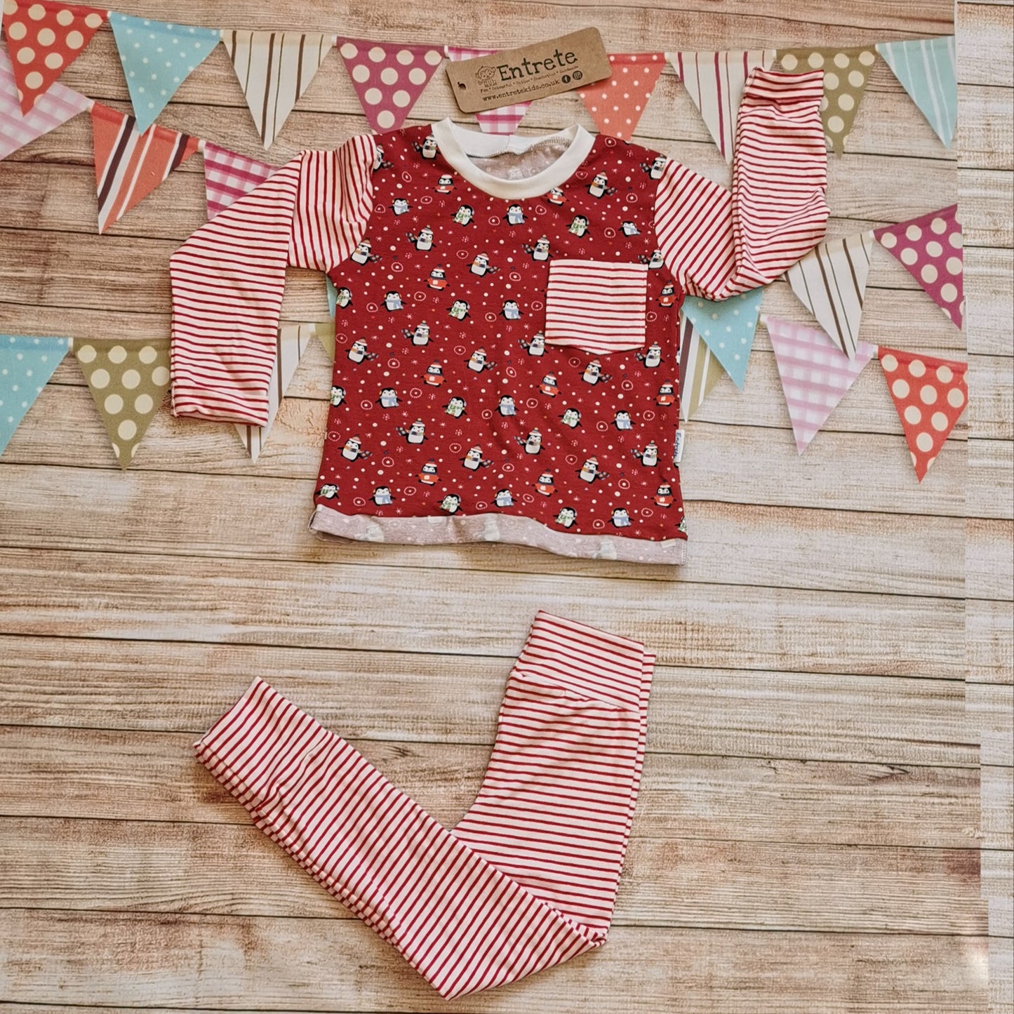 The fun Christmas penguins top shown as a set with matching red striped leggings. (sold separately)