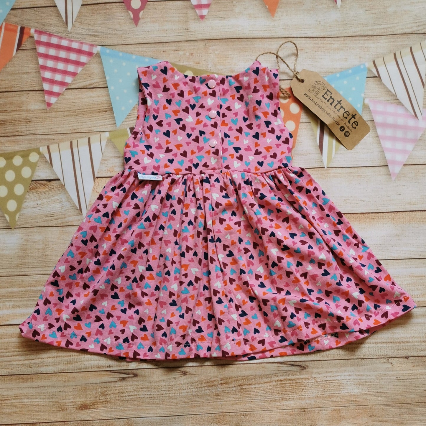 Rear of Girls & Babies sleeveless back popper dress, handmade using pretty pink mini hearts cotton jersey.