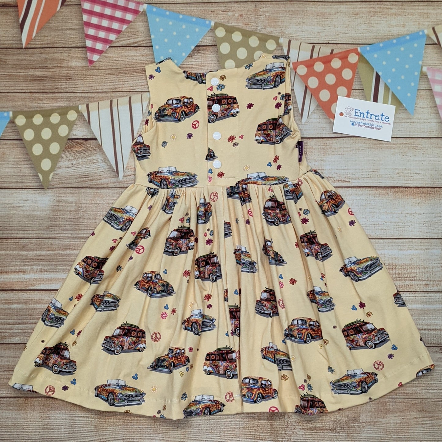 The fun retro hippie cars girls dress, handmade using light yellow hippie cars cotton jersey. Sleeveless model shown from the rear.