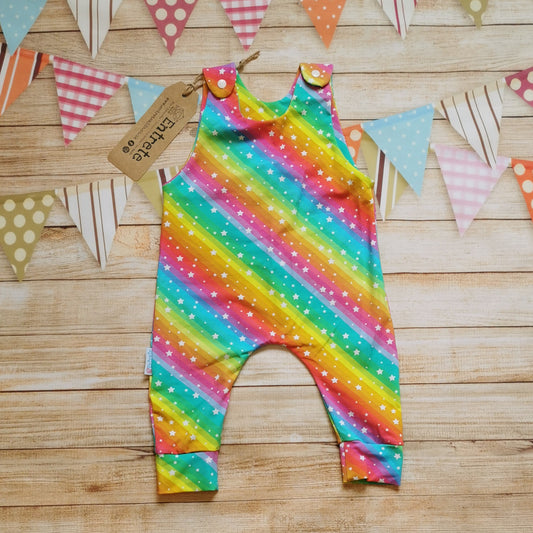 Front of Girls & babies sleeveless romper, handmade using the vivid bright rainbow stars cotton jersey. With shoulder popper entry.