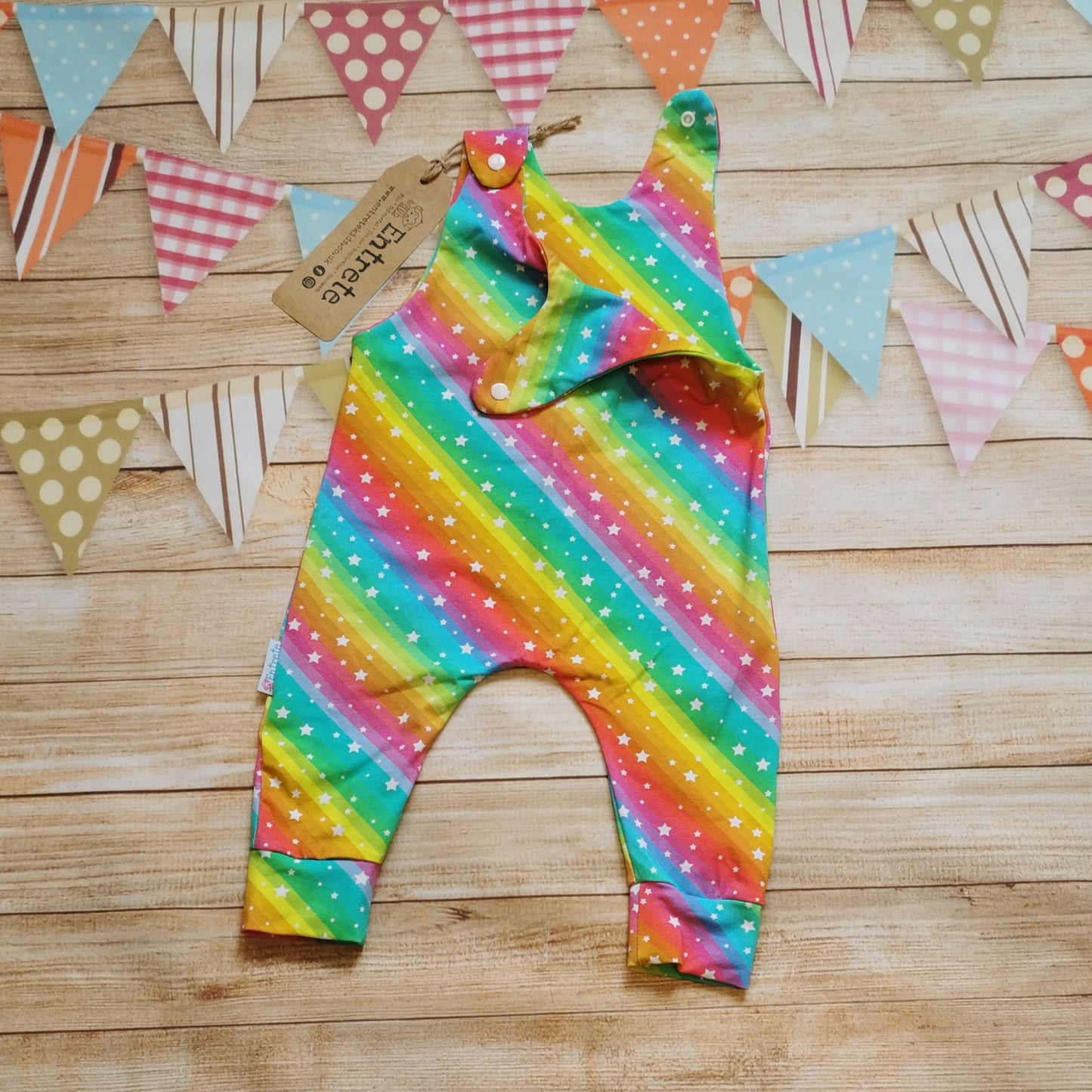 Girls & babies sleeveless romper, handmade using the vivid bright rainbow stars cotton jersey. With shoulder popper entry, shown with one shoulder open.