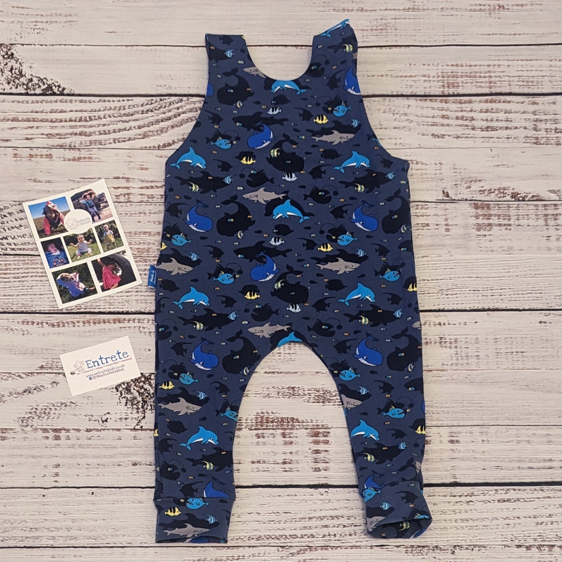 Kids sea life sleeveless romper, packed full of fun marine life. Handmade using navy sea life shadows cotton jersey. Shown from the rear.