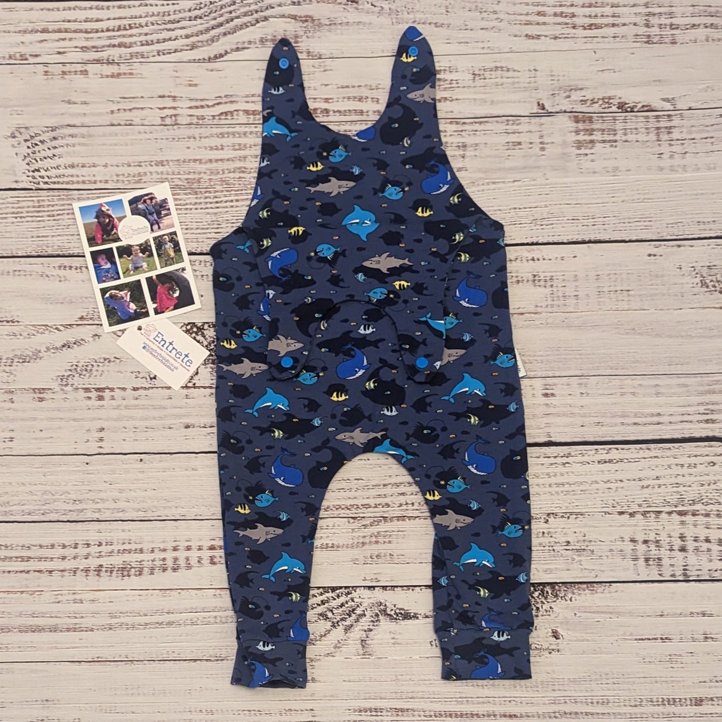 Kids sea life sleeveless romper, packed full of fun marine life. Handmade using navy sea life shadows cotton jersey. Showing the shoulder entry open.