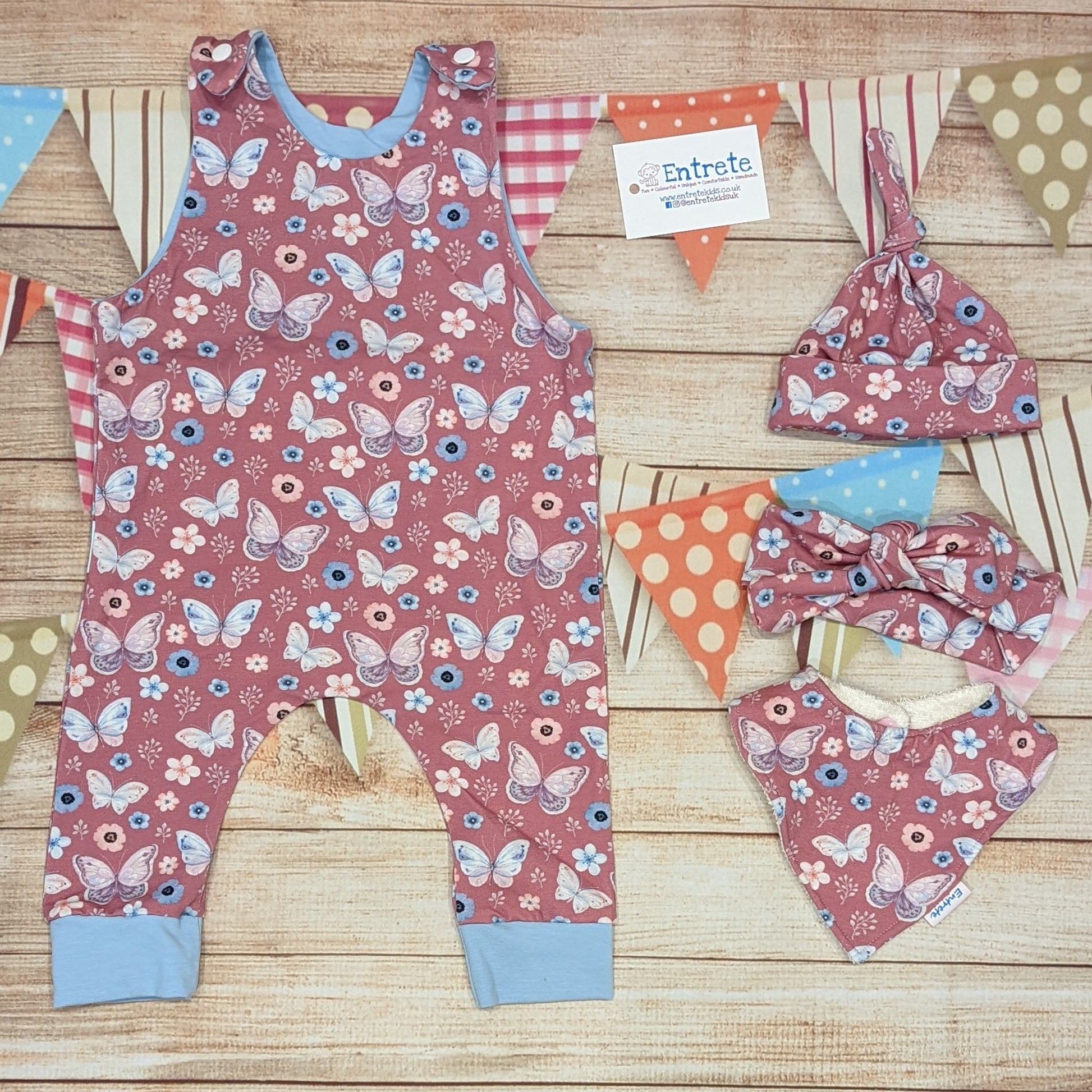 Pretty pink butterflies on contrasting sky blue sleeveless romper. Handmade using organic pink butterflies cotton jersey and sky blue cotton jersey.  Shown with matching tie top hat, headband and bamboo bib.