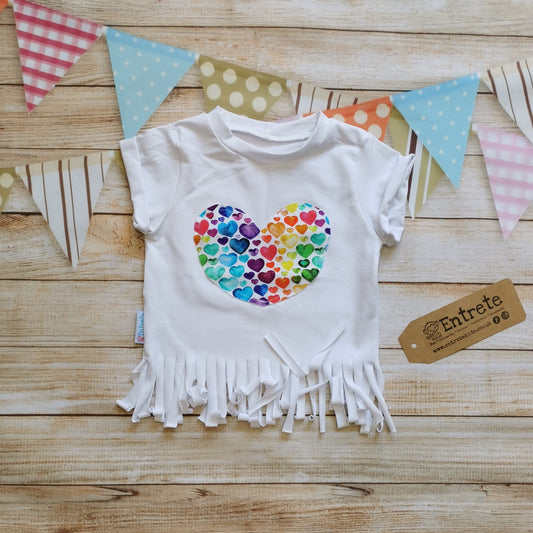 Gorgeous watercolour rainbow hearts heart tassel t-shirt. Lovingly handmade with rolled cuffs and tassels at the waist.