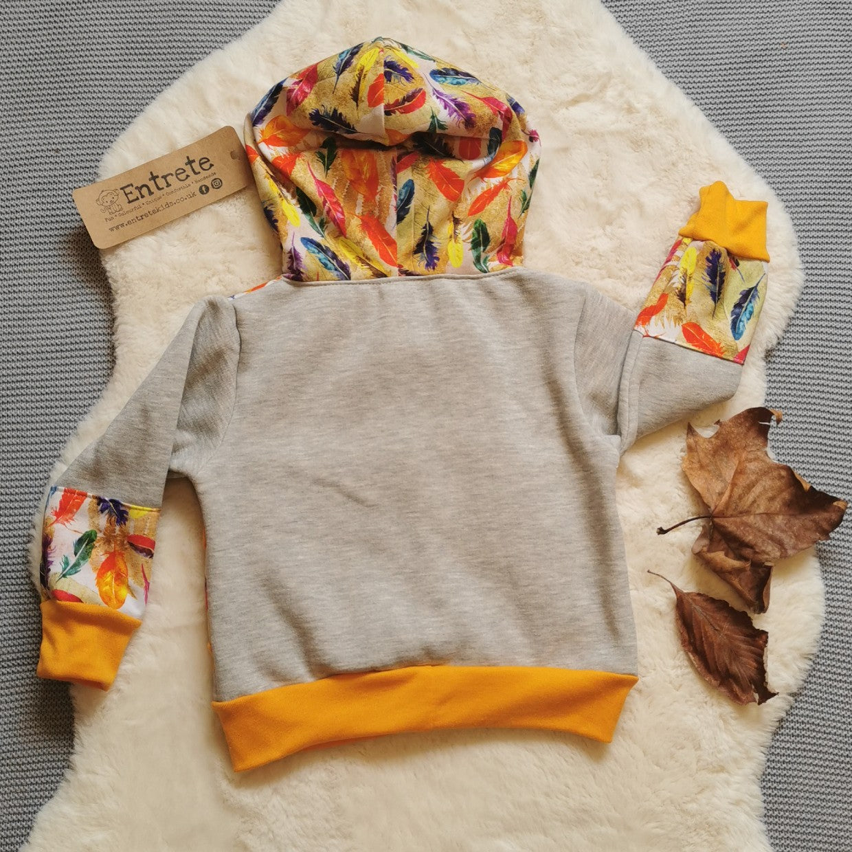 The colourful feathers hoodie, handmade using light grey cotton sweatshirt fleece, feathers cotton jersey and yellow cotton ribbing. Shown from the rear.